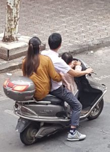 Moped with husband, wife, and child.
